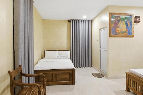 a small bedroom with a bed and a chair at Muthu Hiriketiya in Dickwella