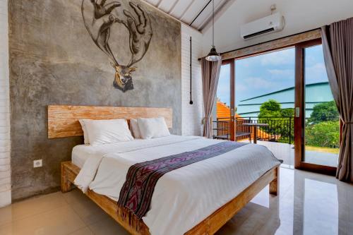 a bedroom with a bed with a deer head on the wall at The Daun Bali in Canggu