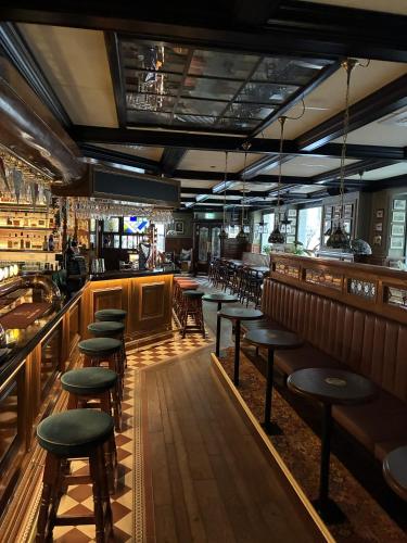 a bar with tables and chairs in a restaurant at Hotel Bishops Arms Malmö in Malmö