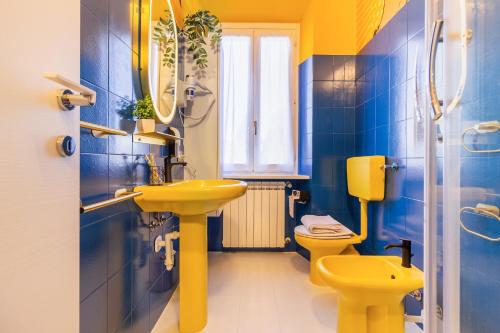 a bathroom with a yellow sink and a toilet at Black & White or Pop Art - Design Apartments with Parking & WiFi in Saronno