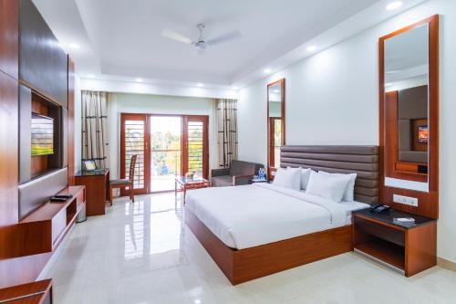 a bedroom with a bed and a flat screen tv at Silver Oak Resort in Rājankunti
