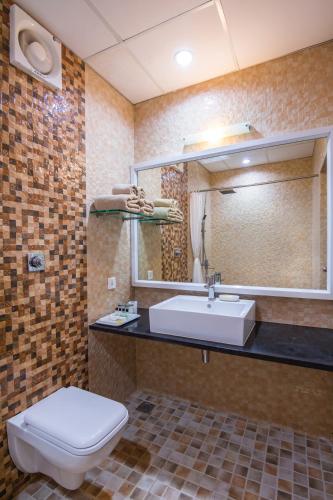 a bathroom with a sink and a toilet and a mirror at Silver Oak Resort in Rājankunti