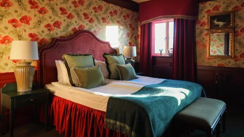 a bedroom with a bed in a room with floral wallpaper at Lejondals Slott in Bro