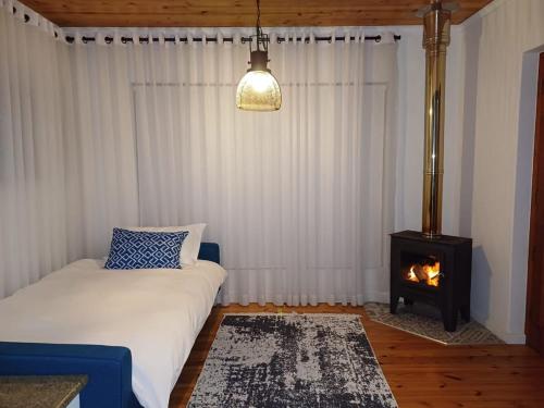 a bedroom with a bed and a fire place at Oystercatcher Guest House in Wilderness