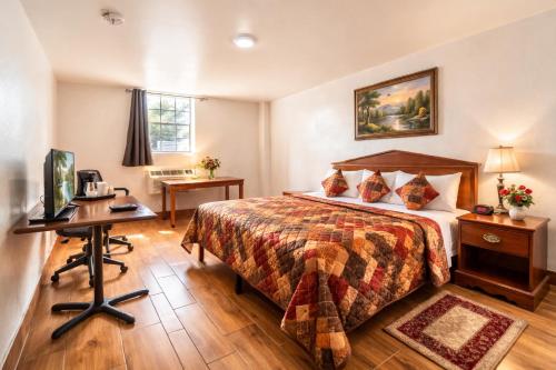 a hotel room with a bed and a desk at Hotel O Colonial Inn Brownsville Tx in Brownsville