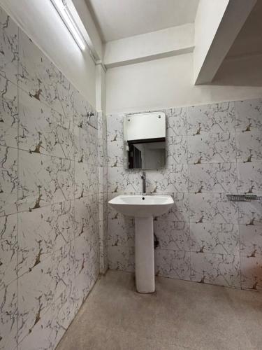 a bathroom with a sink and a mirror at JKR residency in Shillong