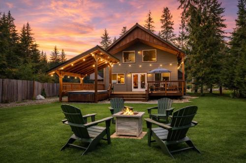 a house with chairs and a fire pit in the yard at Paws in the Mountains by NW Comfy Cabins in Leavenworth
