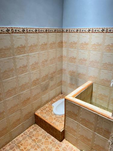 a bathroom with a tub and a toilet in it at Zethira Homestay Syariah in Tabing