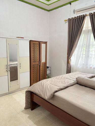 a bedroom with a bed and a window at Zethira Homestay Syariah in Tabing