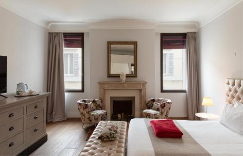 a bedroom with a bed with a fireplace and two chairs at Casa Gugù Room & Breakfast in Ravenna