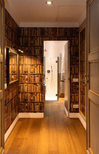 a hallway with bookshelves and a door leading into a library at Casa Gugù Room & Breakfast in Ravenna
