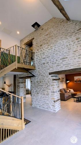 a living room with a brick wall at Chez le Paul Jacques in Seigny