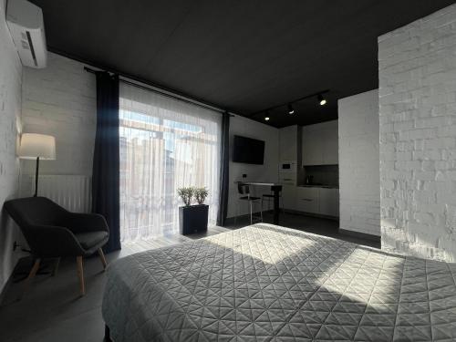 a bedroom with a bed and a chair and a window at Kalinova Sloboda Apart РЕЗЕРВНЕ ЖИВЛЕННЯ in Krykhivtsi