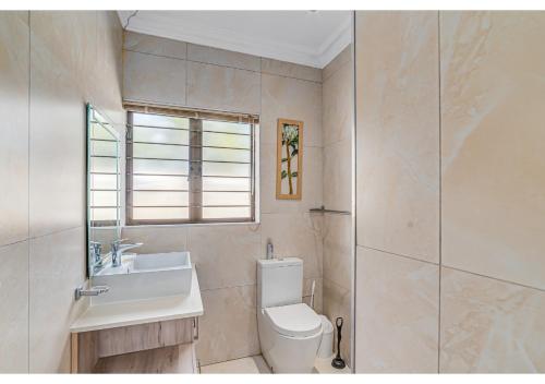 a bathroom with a toilet and a sink and a shower at Mtunzi Park 18, Scottburgh in Vosburg