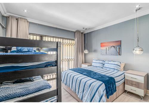 two bunk beds in a bedroom with blue walls at Mtunzi Park 18, Scottburgh in Vosburg