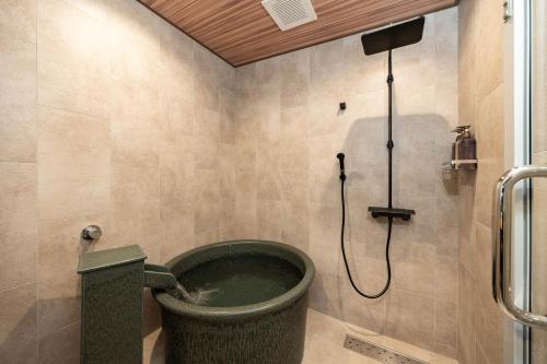 a bathroom with a bucket of water in a shower at JAPAVISTA Yumeno in Osaka