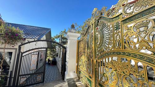 an ornate golden gate in front of a house at Mây Villa Garden Đà Lạt in Xuan An