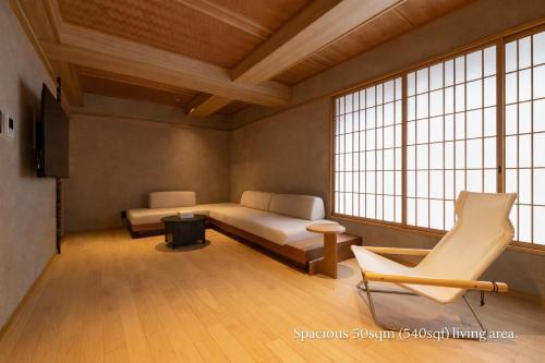 a room with a bed and a couch and a chair at soyo-ne kyoto sanjo in Kyoto