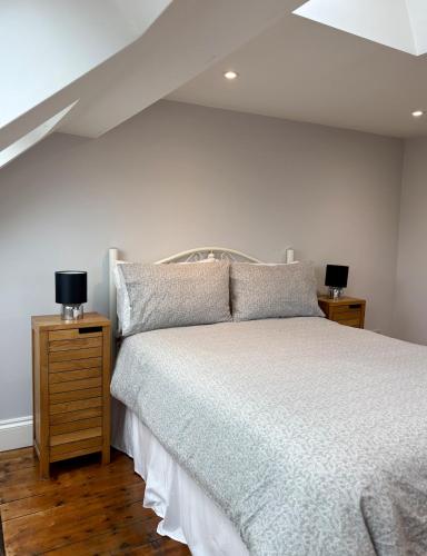 a bedroom with a bed and two night stands with lamps at FRESH Flat in Leek, Staffordshire in Leek