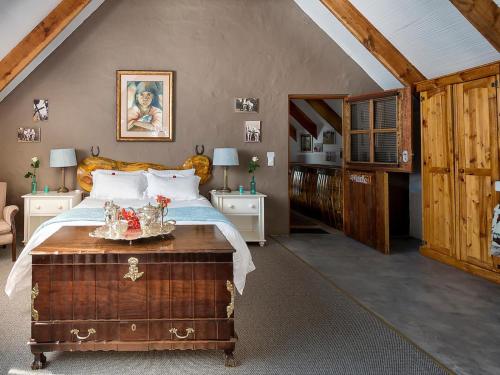 a bedroom with a bed with a wooden headboard at TNiqua Stable Inn in Plettenberg Bay