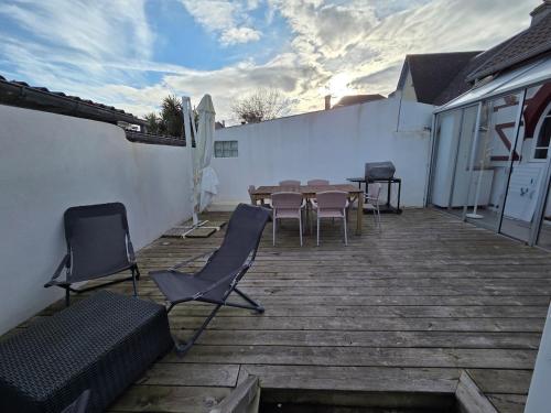 a patio with a table and chairs and a fence at Charmante maison de bord de mer avec terrasse in Luc-sur-Mer
