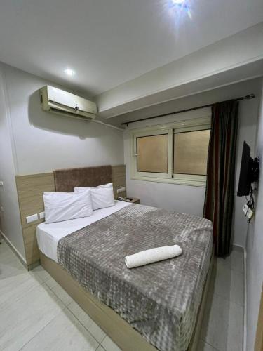 a bedroom with a bed with a white pillow on it at Bostan Hotel in Cairo