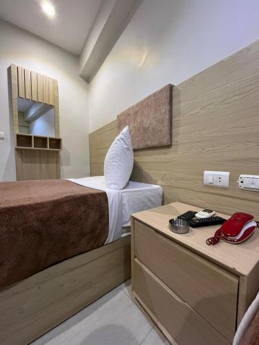 a hotel room with a bed and a telephone at Bostan Hotel in Cairo