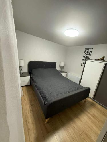 a bedroom with a black bed in a room at Tęczowy Domek - Balia z hydromasażem in Darłowo