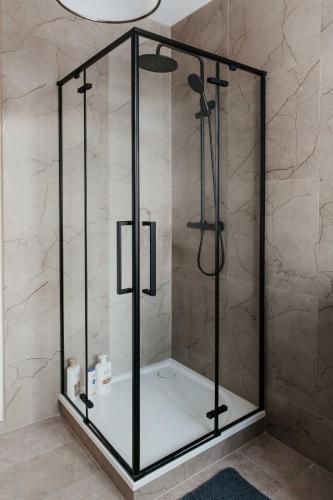 a shower with a glass enclosure in a bathroom at STRIĶU15 - Plašs studio dzīvoklis in Saldus