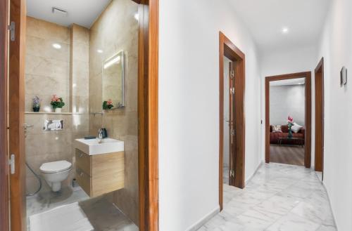 a bathroom with a white toilet and a sink at OXANA By Atlasia in Agadir