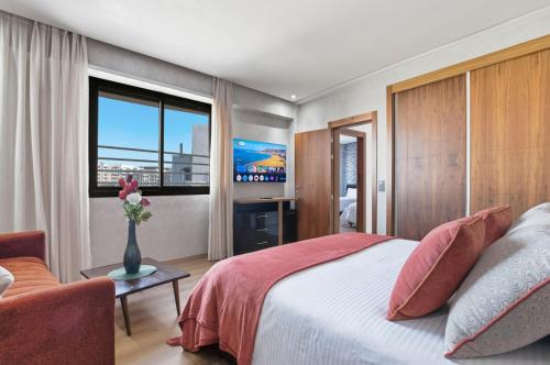 a bedroom with a large bed and a tv at OXANA By Atlasia in Agadir