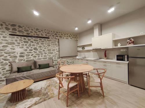 a kitchen and a living room with a table and chairs at Meteora Kalimera 1 in Kalabaka