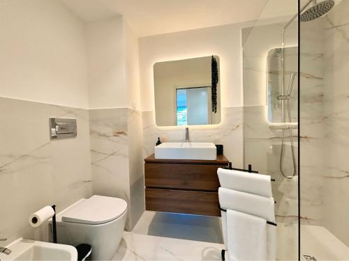 a bathroom with a sink toilet and a mirror at Star Light Apartment in Câmara de Lobos