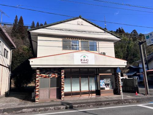 a building on the corner of a street at ゲストハウスまみむ in Mamihara