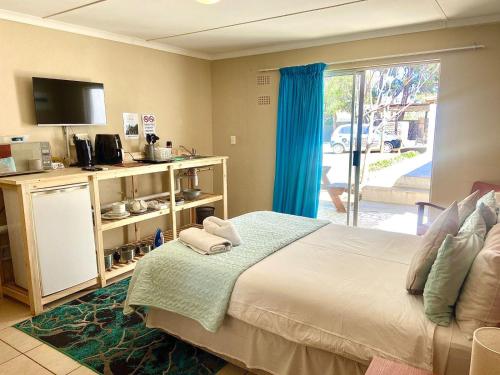 a bedroom with a bed and a sliding glass door at Akkerdam Bed and Breakfast in Calvinia