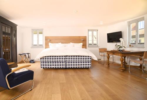 a bedroom with a bed and a desk and a television at Hästens Boutique Biohotel - chez Douverne in Sommerach