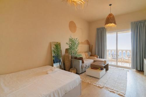 una sala de estar con dos camas y un sofá en The Sandstone Studio, en Ras al Khaimah