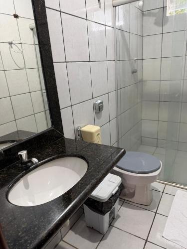 a bathroom with a sink and a toilet at Plaza Hotel in Mineiros