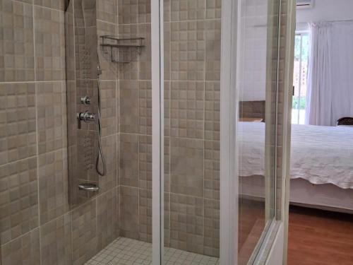 a shower with a glass door in a bedroom at Akkerdam Bed and Breakfast in Calvinia