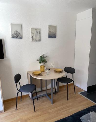 a dining room table with three chairs and a table and chairsktop at Studio Vitalis in Zermatt