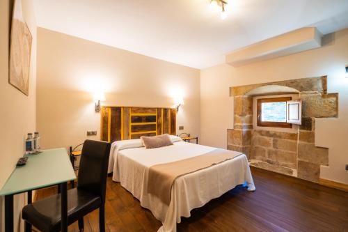 a bedroom with a bed and a table and a desk at Palacio de Arce in Puente Arce