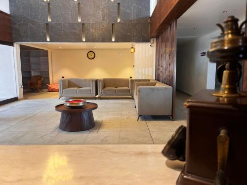 a lobby with couches and a table in a room at Hotel Oxina Cizel in Kodaikānāl