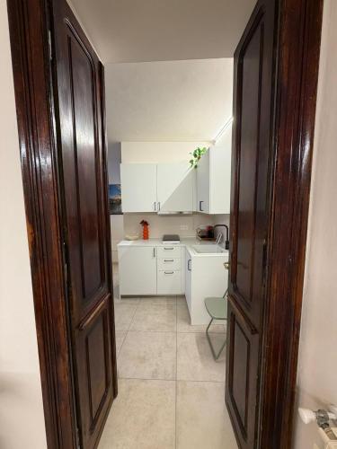 an open door to a kitchen with white cabinets at Casa Bago in Ivrea