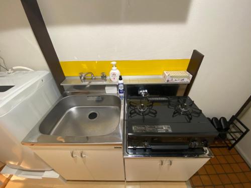 a kitchen with a sink and a stove at Luna Heights Miyake by Tranova in Kichijōji