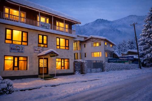 a building with lights on in the snow at Rainbow Palace Pahalgam in Pahalgām