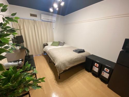 a bedroom with a bed and a potted plant at Luna Heights Miyake by Tranova in Kichijōji