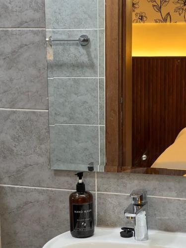a soap dispenser sitting on top of a bathroom sink at Jenn Suites - Nakuru Town in Nakuru