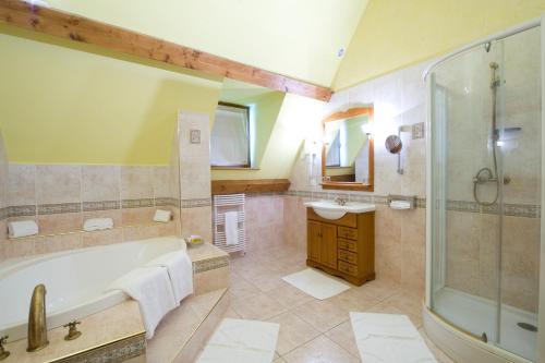 a bathroom with a tub and a shower and a sink at Resort Golf Château de Salles in Vezac