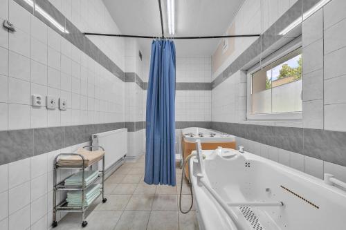 a white bathroom with a tub and a sink at Lázeňský dům Erika in Františkovy Lázně