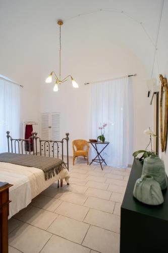 a bedroom with a bed and a chair and a table at Il Da Vinci Apartment in Giovinazzo